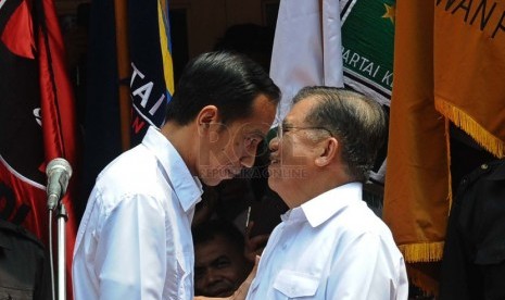   Pasangan Capres-cawapres PDIP Joko Widodo (kiri) dan Jusuf Kalla berjabat tangan saat deklarasi pasangan capres di Gedung Joang 45, Jakarta, Senin (19/5). (Republika/Tahta Aidilla)