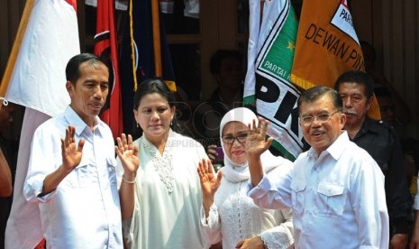   Pasangan Capres-cawapres PDIP Joko Widodo (kiri) dan Jusuf Kalla (kanan) beserta para istri menyapa publik saat deklarasi pasangan capres di Gedung Joang 45, Jakarta, Senin (19/5). (Republika/Tahta Aidilla)