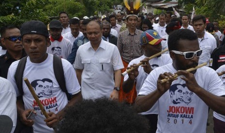 Capres Joko Widodo (tengah) dengan diiringi kelompok musik Suling Tambur berjalan menuju Balai Pertemuan Adat Kampung Hebeaibulu, Yoka, Distrik Heram, Kota Jayapura, Papua, Kamis (5/6). (Antara/Widodo S. Jusuf)