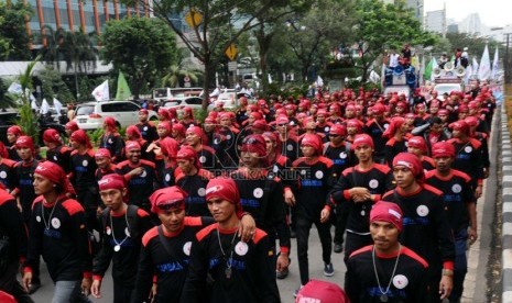 Massa buruh Konfederasi Serikat Pekerja Indonesia (KSPI) se-Jabodetabek melakukan aksi longmarch saat demo di Kantor Kemenkumham, Jakarta, Kamis (19/6).  (Republika/Tahta Aidilla)