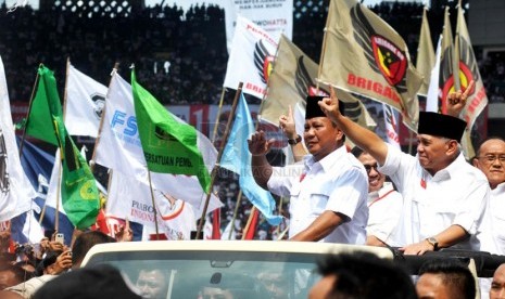   Pasangan Capres dan Cawapres nomor urut satu Prabowo serta-Hatta Rajasa melambaikan tangan menyapa simpatisan saat masuk area Kampanye Akbar di Gelora Bung Karno, Jakarta, Ahad (22/6). (Republika/ Wihdan)