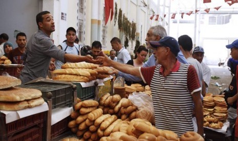   Warga membeli roti pada hari pertama bulan suci Ramadhan, di pusat kota Tunisia, Ahad (29/6).  (Reuters/Zoubeir Souissi)