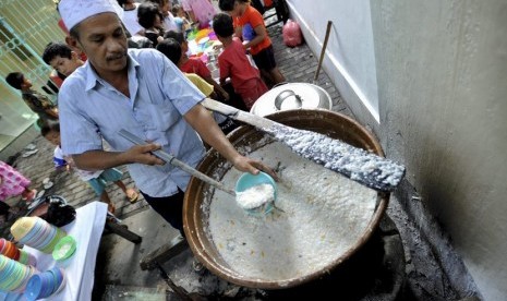  Pengurus masjid menuangkan bubur India ke dalam mangkuk untuk hidangan berbuka puasa, di Masjid Jami Pekojan Semarang, Senin (30/6).   (Antara/R. Rekotomo)