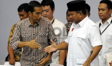 Calon presiden nomor urut satu Prabowo Subianto (kanan) dan calon presiden nomor urut dua Joko Widodo (kiri) berjabat tangan usai pengumuman laporan harta kekayaan di Kantor KPU, Jakarta, Selasa (1/7).(Republika/Aditya Pradana Putra). 