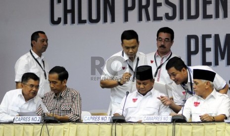   Pasangan capres Prabowo Subianto-Hatta Rajasa (kanan) dan pasangan capres Joko Widodo-Jusuf Kalla, berbincang dengan timses jelang penyampaian laporan harta kekayaan dari di Kantor KPU, Jakarta, Selasa (1/7). (Republika/Aditya Pradana Putra)