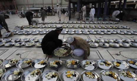  Sejumlah relawan menyiapkan hidangan untuk berbuka puasa saat bulan suci Ramadhan, di luar sebuah masjid di Karachi, Pakistan, Senin (30/6). (AP/ Fareed Khan)