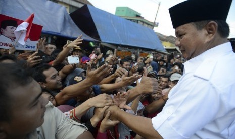   Capres Prabowo Subianto menyapa warga saat mengunjungi pasar Ciparay, Bandung, Jabar, Kamis (3/7).   (Antara/Prasetyo Utomo)