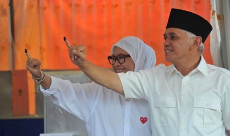 Cawapres nomer urut satu Hatta Rajasa (kanan) dan istrinya Oke Rajasa menunjukkan jari usai mencoblos di TPS 01 Dusun I  Desa Jejawi Kecamatan Jejawi Kabupaten Ogan Komering Ilir (OKI), Sumsel, Rabu (9/7).(Antara/Feny Selly)