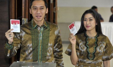 Edhie Baskoro Yudhoyono (kiri) dan istrinya Aliya Rajasa (kanan) menunjukkan kertas suara saat menyalurkan hak suaranya pada Pilpres 2014 di TPS 06 Kompleks Sekolah Alam Cikeas, Bogor, Rabu (9/7).(Antara/Andika Wahyu)