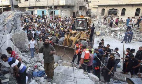  Warga Palestina bersama tim penyelamat mencari korban di bawah reruntuhan rumah yang hancur akibat serangan udara Israel di Rafah di Jalur Gaza, Jumat (11/7).  (Reuters/Ibraheem Abu Mustafa )