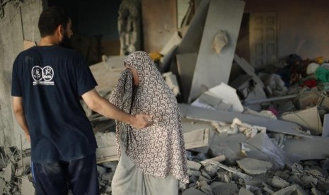 Seorang wanita Palestina menangis melihat rumahnya yang hancur akibat serangan udara Israel, di Kota Gaza, baru-baru ini.  (Reuters/Mohammed Salem)