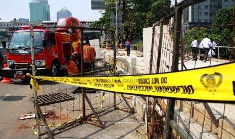  Sejumlah petugas melakukan pendinginan pipa gas PGN yang bocor dari lubang gorong-gorong di kawasan SCBD Jalan Jenderal Sudirman, Jakarta, Kamis (17/7). (Republika/ Yasin Habibi)