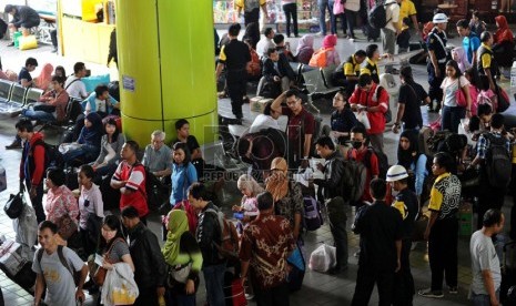  Pengguna jasa kereta api mengantre saat akan memasuki pintu masuk selatan Stasiun Gambir, Jakarta, Jumat (25/7). (Republika/Tahta Aidilla)