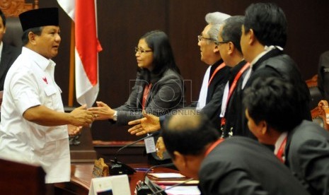  Capres Prabowo Subianto (kiri) menjabat tangan jajaran komisioner KPU dan kuasa hukumnya jelang sidang perdana perkara Perselisihan Hasil Pemilihan Umum (PHPU) Pilpres 2014 di Mahkamah Konstitusi (MK), Jakarta, Rabu (6/8). (Republika/Aditya Pradana Putra)