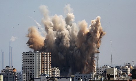  Asap mengepul dari bangunan di utara kota Gaza, Jumat (8/8), akibat serangan pertama militer Israel sejak  gencatan senjata selama tiga hari.  (EPA/Mohammed Saber)