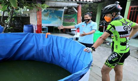 Machmudi Hariono (45), eks napiter sedang berdialog dengan Gubernur Jawa Tengah, Ganjar Pranowo (kanan) yang menyempatkan singgah di kolam budidaya lele yang dikelola bersama sejumlah eks napiter, di lingkungan Kelurahan Gisikdrono, Kecamatan Semarang Barat, Kota Semarang, Kamis (4/3). 