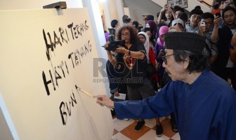 Maestro lukis Jeihan Sukmantoro melukiskan puisinya pada pembukaan pameran lukisan dan puisi 'Lima Rukun' di Studio Jeihan, Bandung, Sabtu (28/9). (Republika/Edi Yusuf)