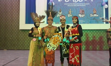 Mahasiswa AMIK BSI Pontianak, Satriansyah (kedua dari kiri) dan Fitri Febriyani (kiri) menjadi juara pertama lomba pakaian adat tingkat Provinsi Kalimantan Barat.    