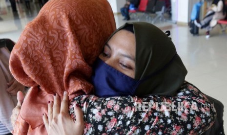 Mahasiswa asal Aceh yang kuliah di Wuhan Hayatul Hikmah (kanan) yang telah melewati masa karantina dan observasi Coronavirus Disease (COVID-19) selama 14 hari di Natuna, Kepulauan Riau tiba di terminal Bandara Internasional Sultan Iskandar Muda, Aceh Besar, Aceh, (17/2/2020). 