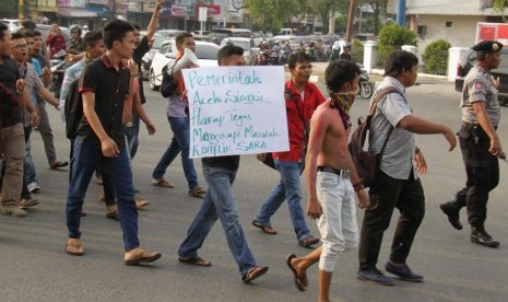 Mahasiswa asal Kabupaten Aceh Singkil, Aceh, membawa poster dan spanduk saat berunjukrasa di Bundaran Simpang Lima, Banda Aceh, Selasa (13/10). 