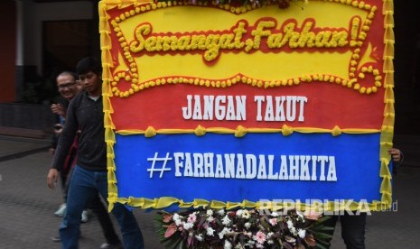 Mahasiswa membawa karangan bunga yang berisi dukungan kepada mahasiswa berkebutuhan khusus korban bullying berinisial MF di depan gedung rektorat Kampus Gunadarma, Depok, Jawa Barat, Senin (17/7). 