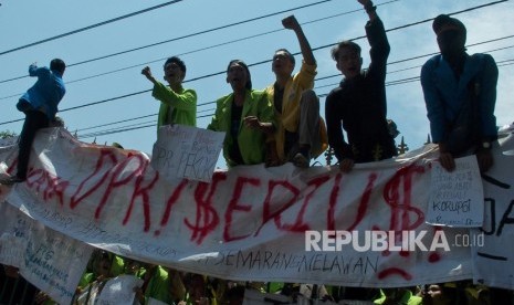 Mahasiswa meneriakkan tuntutannya dari atas gerbang Gedung DPRD Jateng saat berunjuk rasa menolak UU KPK hasil revisi dan RUU KUHP di Semarang, Jawa Tengah, Selasa (24/9/2019). 