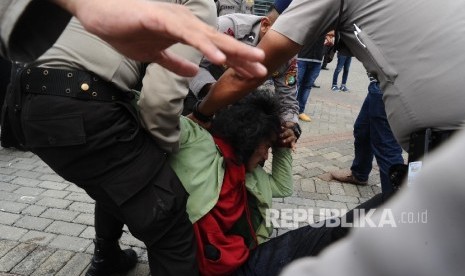  Mahasiswa tergabung dalam Gerakan Bersama Lawan Industri Rokok (Gebrak) diamankan petugas saat melakukan aksi penolakan World Tobacco Process And Machinery (WTPM) di Jiexpo, Jakarta, Rabu (27/4). (Republika/Tahta Aidilla)