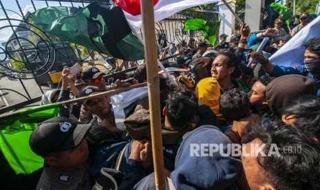 Mahasiswa terlibat aksi dorong-dorongan dengan aparat keamanan pada unjuk rasa menolak RUUKUHP di depan Kantor DPRD Sulawesi Tengah di Palu, Selasa (24/9/2019). 