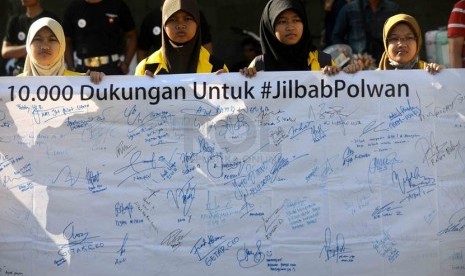   Mahasiswa UI menggelar aksi simpatik mendukung Polisi Wanita (Polwan) berjilbab di Bundaran HI, Jakarta, Ahad (20/4). (Republika/Agung Supriyanto)