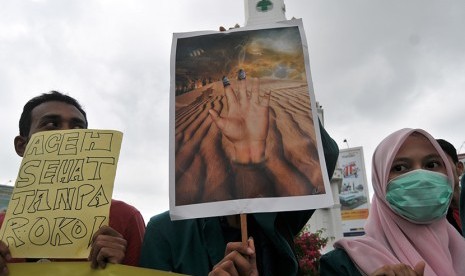  Mahasiswa yang tergabung dalam Aliansi Pemuda Aceh Anti Rokok (APAR) membawa poster dan spanduk saat aksi memperingati Hari Tanpa  Tembakau Sedunia di Bundaran Simpang Lima, Banda Aceh, Ahad (31/5). (Antara/Ampelsa)