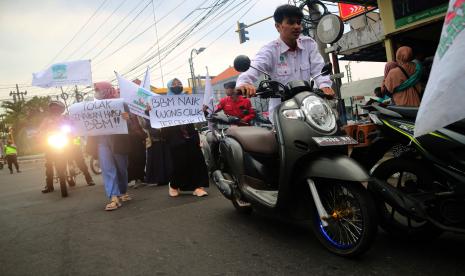 Mahasiswa yang tergabung dalam Kesatuan Aksi Mahasiswa Muslim Indonesia (KAMMI) berunjuk rasa dengan mendorong motor di Jalan Wahid Hasyim Kabupaten Jombang, Jawa Timur, Kamis (8/9/2022). Aksi mendorong motor menuju gedung DPRD Kabupaten Jombang itu sebagai bentuk aksi penolakan kenaikan harga bahan bakar minyak (BBM). 