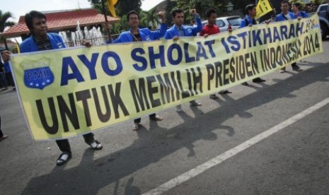 Mahasiswa yang tergabung dalam Pergerakan Mahasiswa Islam Indonesia (PMII) Kabupaten Kudus membentangkan poster yang menghimbau melakukan shalat istikarah untuk memilih Presiden Indonesia 2014 di Alun-alun Kudus, Jateng, Senin (9/6). 