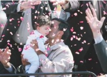 Mahmud Ahmadinejad menggendong bayi