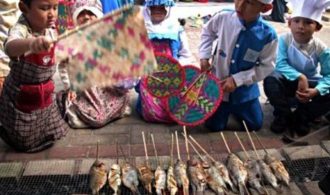 Sejumlah siswa mengikuti kegiatan bakar ikan bersama. Kegiatan bakar ikan yang diikuti 150 siswa tersebut, bertujuan untuk mengenalkan manfaat mengkonsumsi dan cara mengolah ikan yang benar dan sehat. 