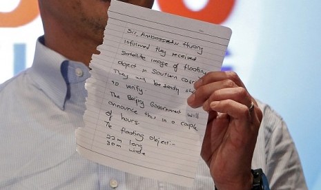 Malaysia's acting Transport Minister Hishammuddin Hussein holds up a note that he has just received on a new lead in the search for the missing Malaysia Airlines Flight MH370, during a news conference at Kuala Lumpur International Airport March 22, 2014.