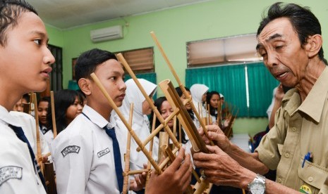 Maman Supratman saat mengajar angklung di SMPN 17 Bekasi, Jawa Barat, Selasa (2/12/2014).