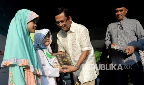 Managing Director Sinarmas Saleh Husin (kedua kanan) bersama Dirut Republika Media Mandiri Agoosh Yoosran (kanan) memberikan wakaf Al-Quran dan Juz'Amma secara simbolis disela acara buka bersama dan santunan anak yatim di Kantor Republika, Jakarta, Sabtu (17/6)