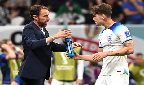 Manajer Inggris Gareth Southgate (Kiri) berbicara dengan bek John Stones selama pertandingan sepak bola grup B Piala Dunia 2022 antara Inggris dan AS di Stadion Al Bayt di Al Khor, Qatar, Sabtu (26/11) dini hari WIB.