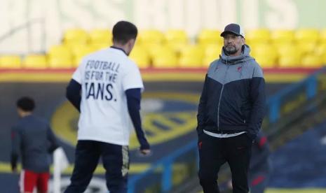 Pelatih Liverpool Juergen Klopp di depan salah seorang pemain Leeds United yang mengenakan kaus protes anti Liga Super Eropa saat pemanasan jelang sepak mula lanjutan Liga Inggris di Stadion Elland Road, Leeds, Inggris, Senin (19/4/2021) waktu setempat.