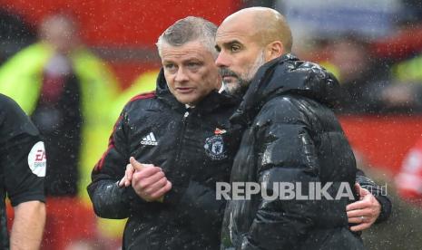 Pelatih Manchester United Ole Gunnar Solskjaer (kiri) dan pelatih Manchester City Pep Guardiola (kanan) berinteraksi setelah pertandingan sepak bola Liga Inggris antara Manchester United dan Manchester City di Manchester, Inggris, Sabtu (6/11/2021).