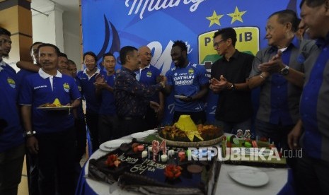 Manajer Persib, Umuh Muchtar menyerahkan kue kepada Michael Essien saat ikut merayakan ulang tahun Persib Bandung ke-84 di Graha Persib, Jalan Sulanjana, Kota Bandung, Selasa (14/3)