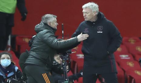  Manajer West Ham David Moyes bertabrakan dengan manajer Manchester United Ole Gunnar Solskjaer, kiri, setelah pertandingan sepak bola putaran ke-5 Piala FA Inggris antara Manchester United dan West Ham United di Old Trafford di Manchester, Inggris, Selasa, 9 Februari 2021. 