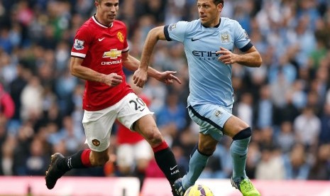 Manchester City's Martin Demichelis (R) is chased by Manchester United's Robin van Persie during their English Premier League soccer match at the Etihad Stadium in Manchester, northern England November 2, 2014