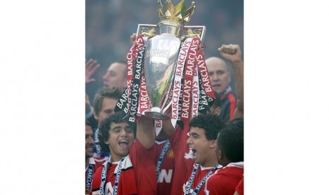 Manchester United's Rafael Da Silva, left, and Fabio Da Silva, right, are seen celebrating with the English Premier League trophy after their match against Blackpool at Old Trafford, Manchester, England, Sunday, May 22, 2011. Manchester United celebrated w