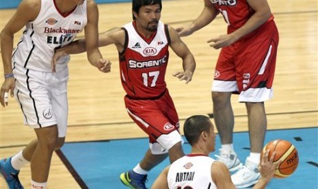 Manny Pacquiao (tengah) saat menjalani debut di kompetisi basket profesional Filipina, PBA, Ahad (19/10).