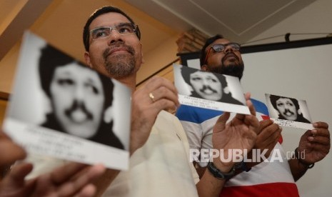  Mantan Anggota TPF dan Analis Politik dan HAM Amiruddin Al-Rahab (kiri) dan Koordinator Kontras Haris Azhar (kanan) menunjukan kartu pos yang bergambar Munir saat menggelar konferensi pers bersama media di Jakarta, Ahad (27/11).