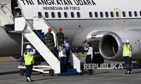 Mantan atlet bulu tangkis Susi Susanti (tengah) membawa api obor Asian Games 2018 turun dari pesawat setibanya di Lanud Adisutjipto, Sleman, DI Yogyakarta, Selasa (17/7). 