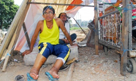 Mantan atlet senam nasional Amin Ikhsan (depan) berada di tenda pengungsian di lokasi pembongkaran lahan kawasan Kiaracondong, Bandung, Jawa Barat, Jumat (7/8). 