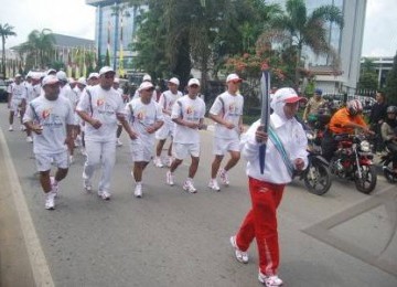 Mantan atlit panahan Kaltim, Hamdiah bersama bersama 70 pelari membawa obor SEA Games XXVI untuk diarak di sejumlah jalan protokol di Samarinda, Kalimantan Timur, Rabu (2/11).