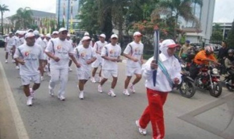 Mantan atlit panahan Kaltim, Hamdiah bersama bersama 70 pelari membawa obor SEA Games XXVI untuk diarak di sejumlah jalan protokol di Samarinda, Kalimantan Timur, Rabu (2/11).